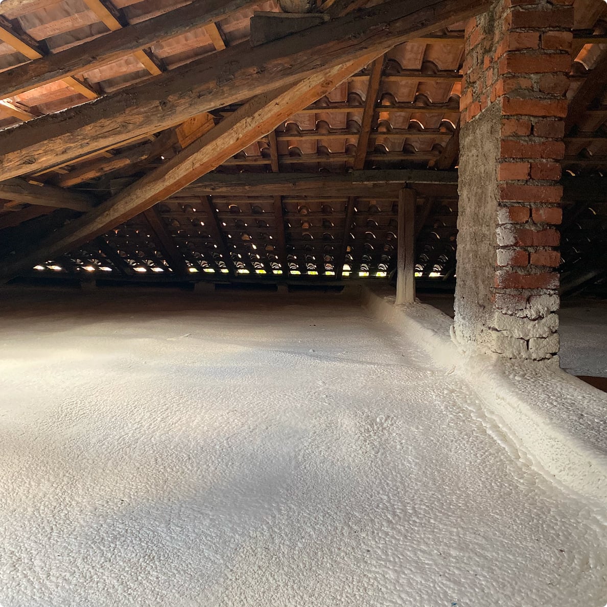 Scatto dell'interno di un sottotetto di una casa con uno strato di poliuretano fresco sul pavimento.