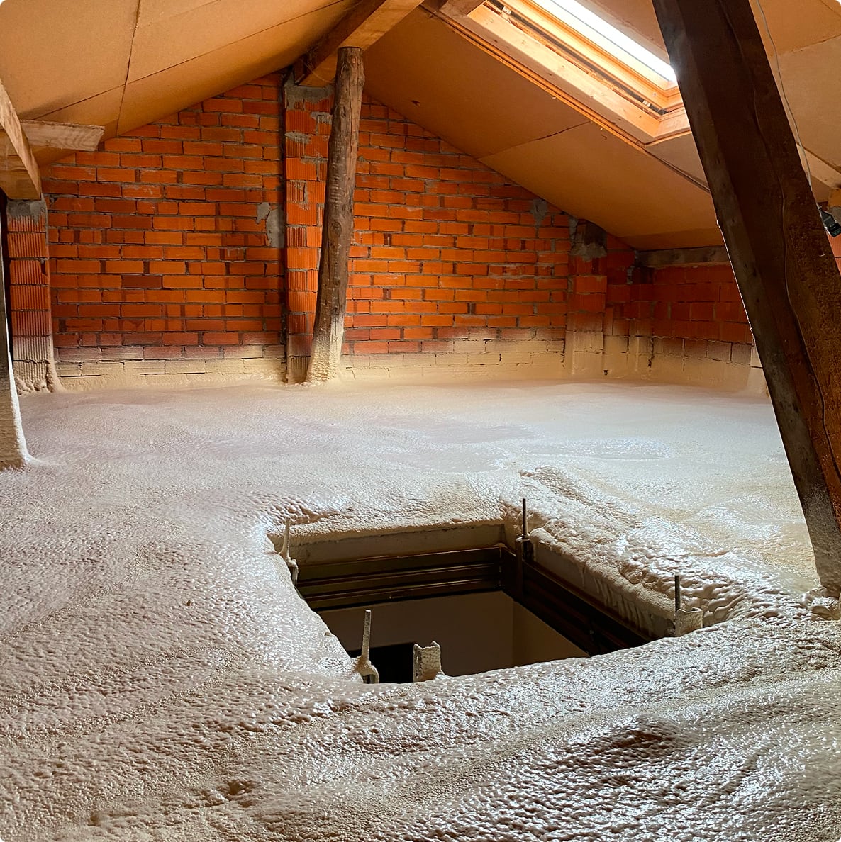 Scatto dell'interno di un sottotetto di una casa con uno strato di poliuretano fresco sul pavimento.